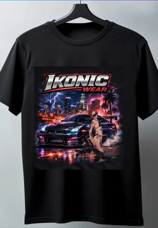 Black t-shirt with 'Ikonic Wear' graphic design featuring a car and person on a cityscape background.