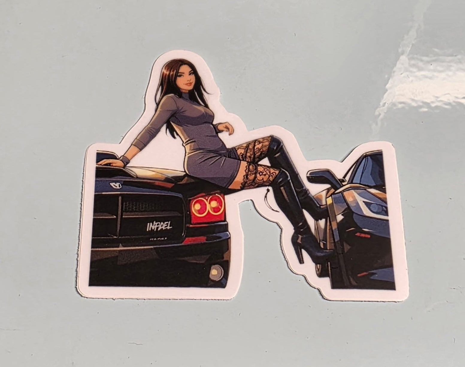 Sticker of a woman sitting on a car with a blurred background
